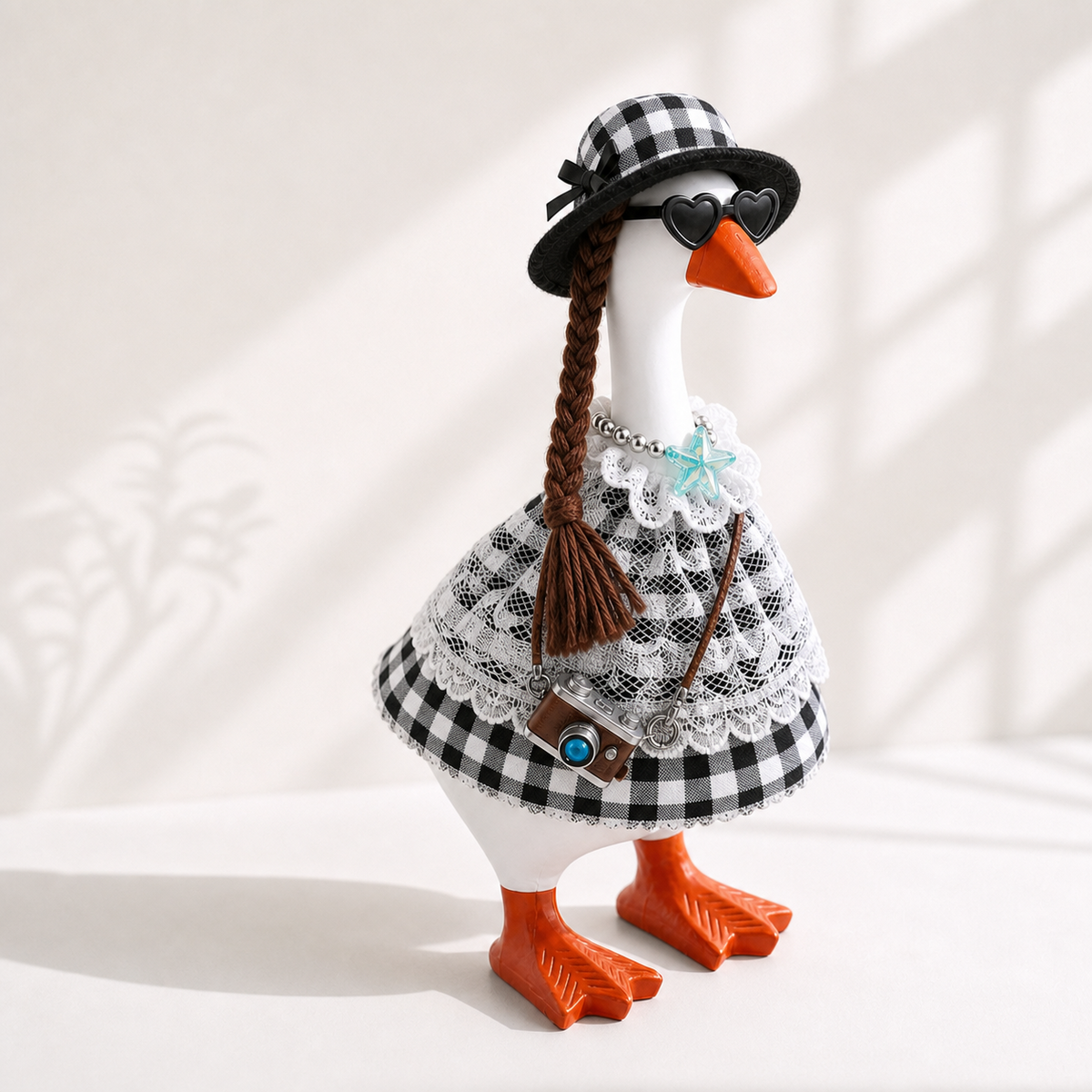 Little Honk black and white gingham outfit set styled on a 7-inch desk goose