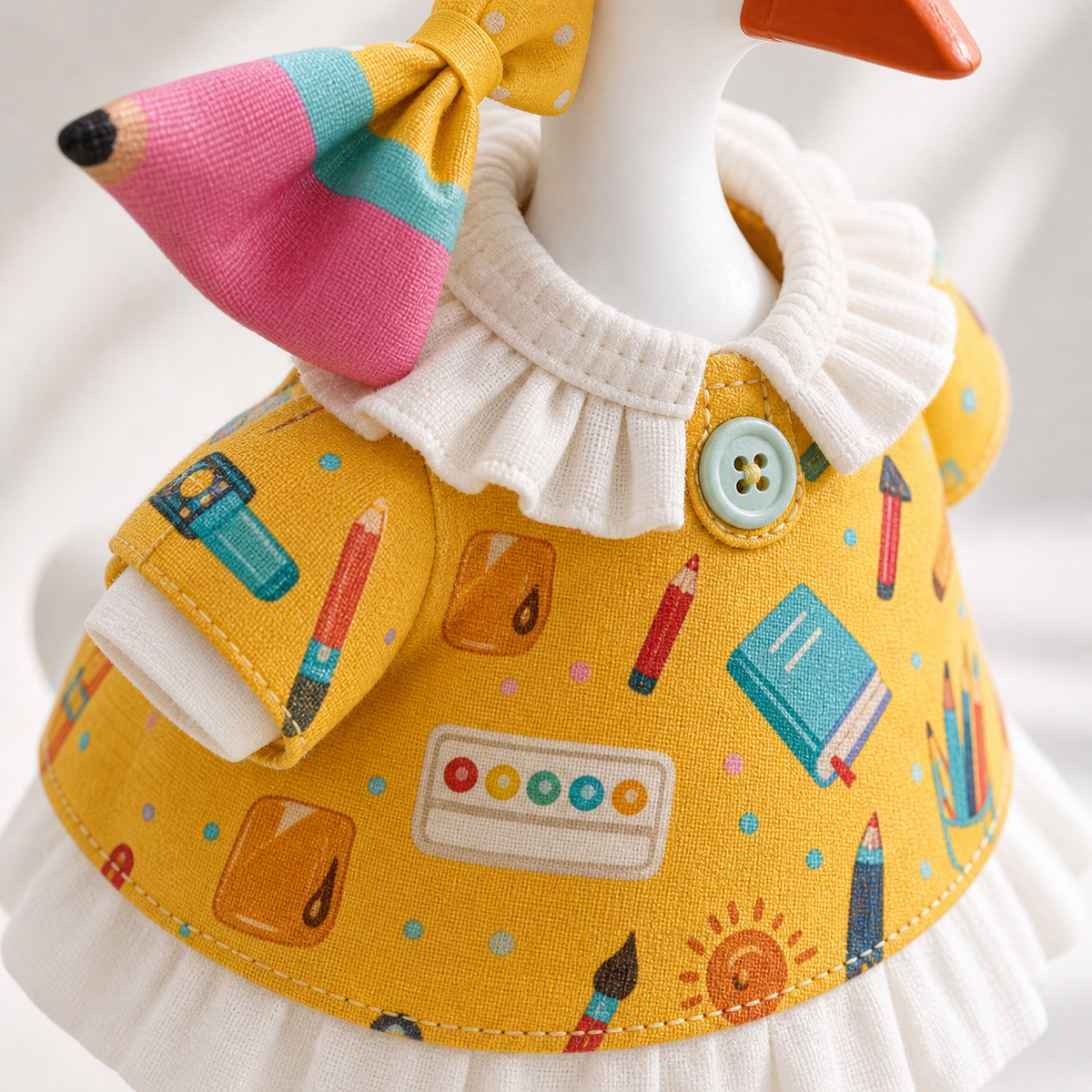 Little Honk yellow stationery-print dress and pencil bow outfit set on a 7-inch desk goose